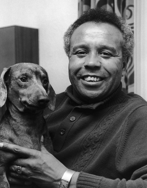 black and white photo of a black man and dog